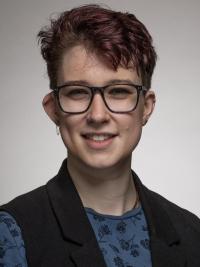 Person with short hair and glasses