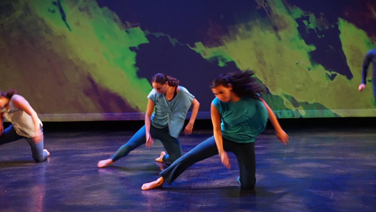 Dancers performing in front of a projection 