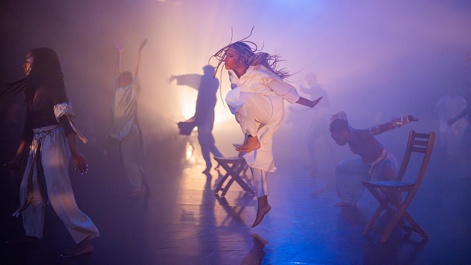 person leaping in white costume