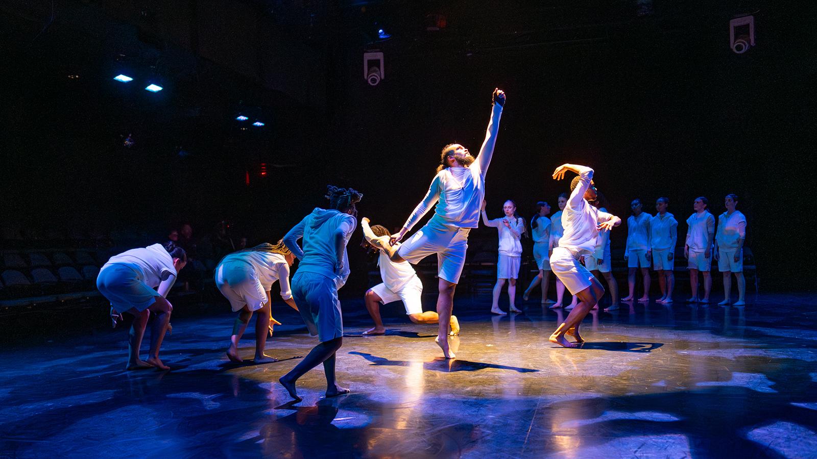 several people on a stage wearing white clothing