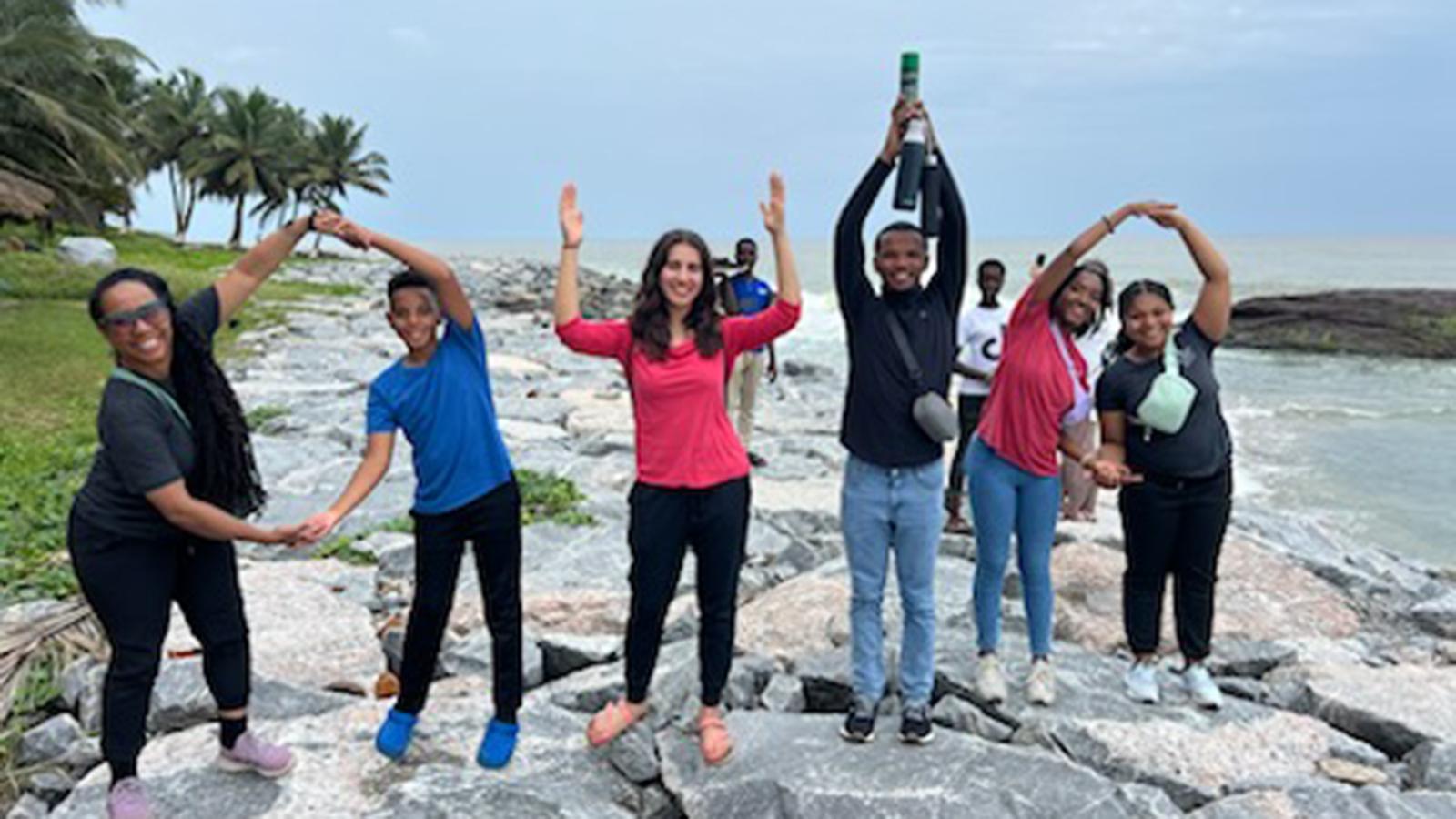 People posing for a group photo on a beach