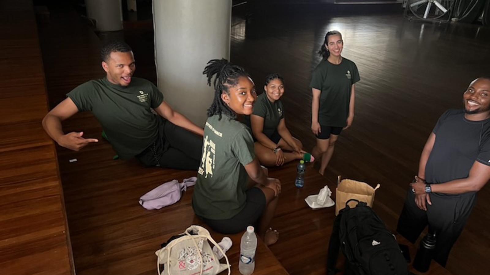 A group of students sitting on a wood floor